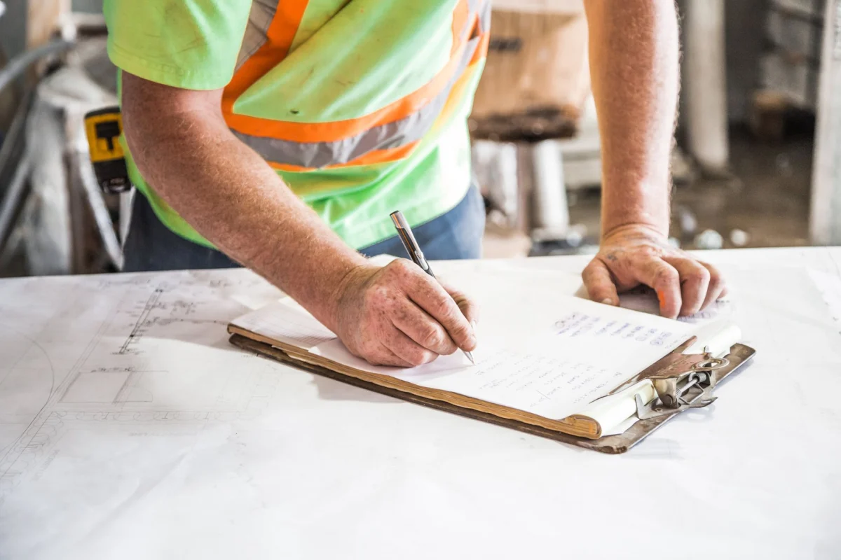 Carnet de relevé et mètre posés sur une table de chantier